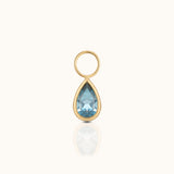 DOVIANA 14K solid gold ear charm with a pear-cut blue topaz gemstone in a polished teardrop bezel setting