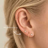 DOVIANA NYC 14K opal bezel flat back earring styled in a curated ear piercing with a gold hoop and triangle CZ stud for minimalist fine piercing jewelry in New York.