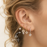 Close-up of a blonde woman wearing a DOVIANA triple marquise-cut CZ dangle ear charm in PVD gold titanium on a hoop. Charm sold separately; hoop not included.
