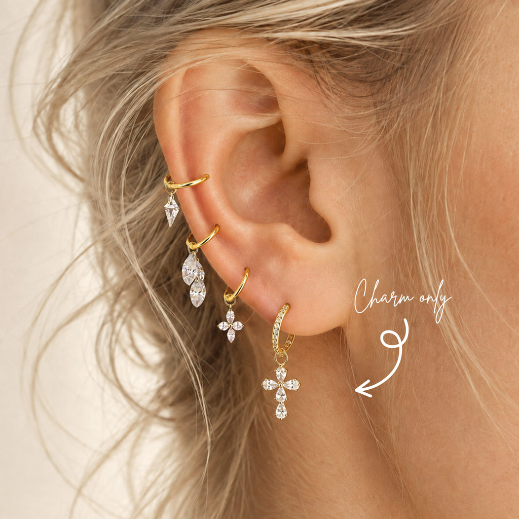 DOVIANA pear-cut CZ cross ear charm in PVD gold titanium, styled on a hoop earring.