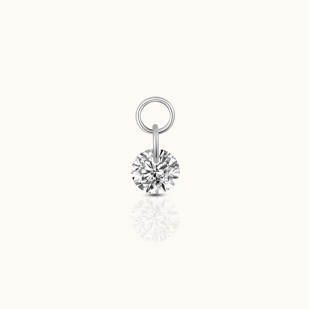 DOVIANA implant-grade titanium ear charm with a round brilliant-cut clear CZ and polished silver-tone connector rings.
