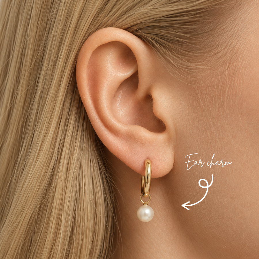 Blonde woman wearing a DOVIANA 14K solid gold Classic Pearl Ear Charm with a round white pearl on a hoop, highlighted by an arrow.
