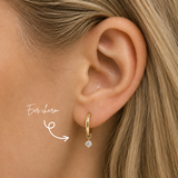 Blonde woman wearing a DOVIANA 14K solid gold round lab-grown diamond ear charm in a four-prong setting on a hoop, highlighted by an arrow.