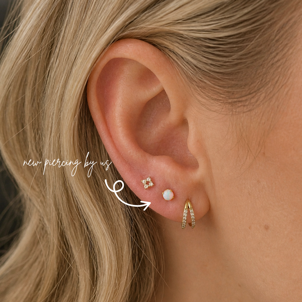 White woman with curly blonde hair wearing DOVIANA 14K solid gold 3mm opal threadless labret flat back earring on lobe, featuring a small round opal stone with soft iridescence and natural skin texture visible