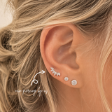 Close-up of 14K solid gold Marquise Cluster CZ crawler threadless flat back earring styled in a curated ear stack with sparkling lobe piercings at DOVIANA NYC.