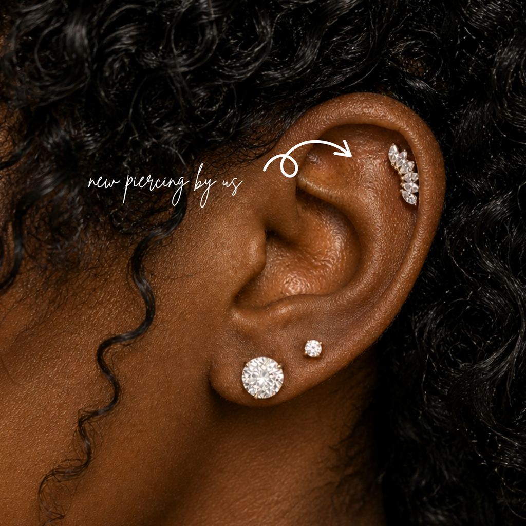 Black woman with curly black hair wearing DOVIANA 14K solid gold marquise cluster CZ crawler threadless labret flat back earring on ear, featuring delicate marquise-cut cubic zirconia stones in a curved crawler design with natural skin texture visible