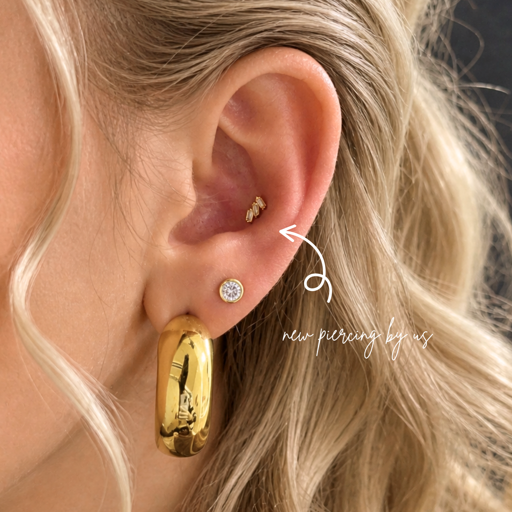 Close-up of ear wearing DOVIANA 14K solid gold triple baguette CZ curved wing threadless labret flat back earring, showcasing dainty cartilage piercing jewelry and elegant everyday ear styling.