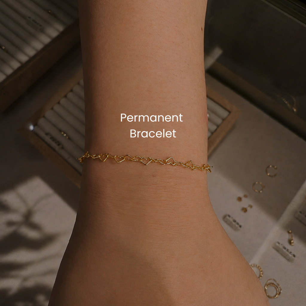 Close-up of gold filled permanent bracelet with heart chain links welded at DOVIANA NYC featuring minimalist forever jewelry and custom permanent bracelet service.