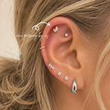 Close-up of curated ear styling featuring Graduated Double Marquise CZ threadless titanium flat back earring with helix and lobe piercings in a minimalist ear stack at DOVIANA NYC.