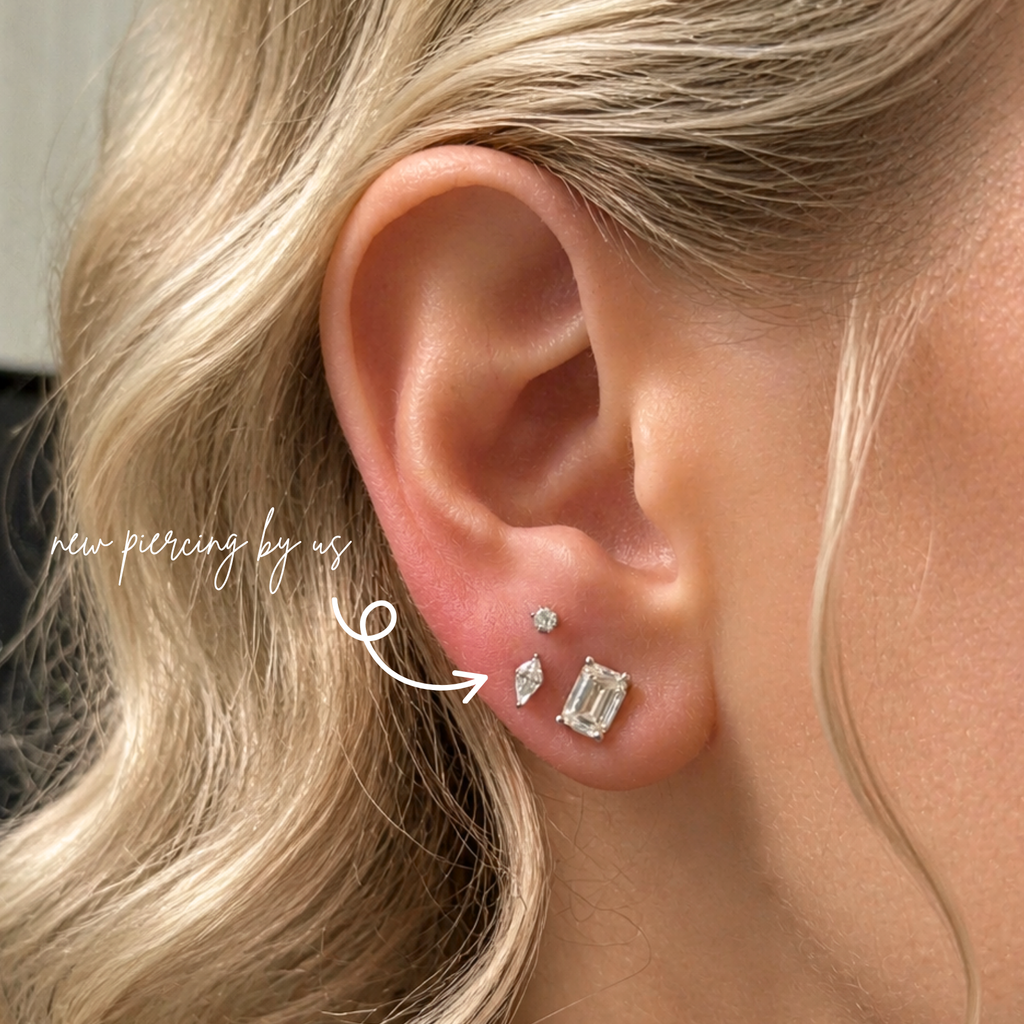 Close-up of a white woman with soft romantic blonde waves wearing DOVIANA kite shaped CZ threadless labret flat back earring in titanium PVD gold, styled in a curated ear stack with diamond studs, showcasing dainty fine jewelry for everyday wear.