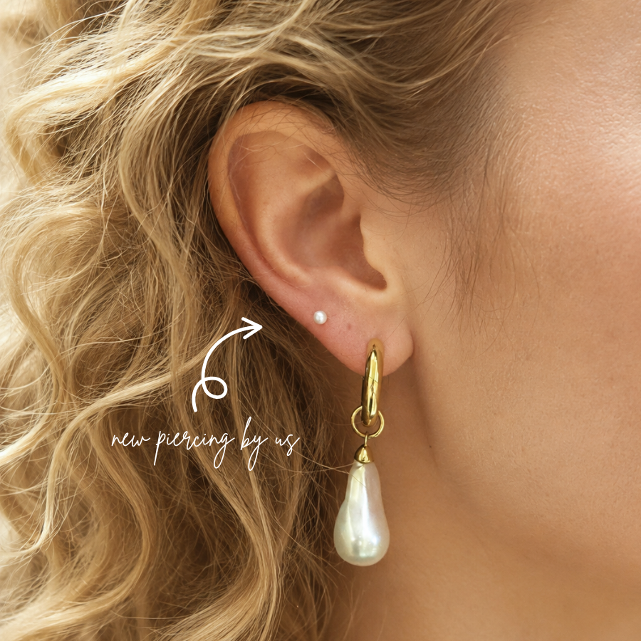 DOVIANA natural pearl threadless flat back earring worn in a fresh upper lobe piercing on a blonde model.