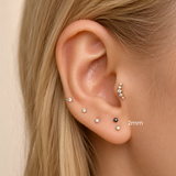 DOVIANA NYC 2mm flat back earring styled in a curated ear piercing with tiny CZ studs, black gemstone stud, and minimalist fine piercing jewelry for everyday ear stacks in New York.