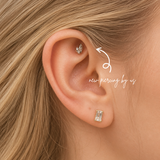 DOVIANA NYC curated ear piercing featuring a crystal leaf cartilage stud, emerald cut lobe earring, and minimalist fine piercing jewelry for everyday ear stacks in New York.