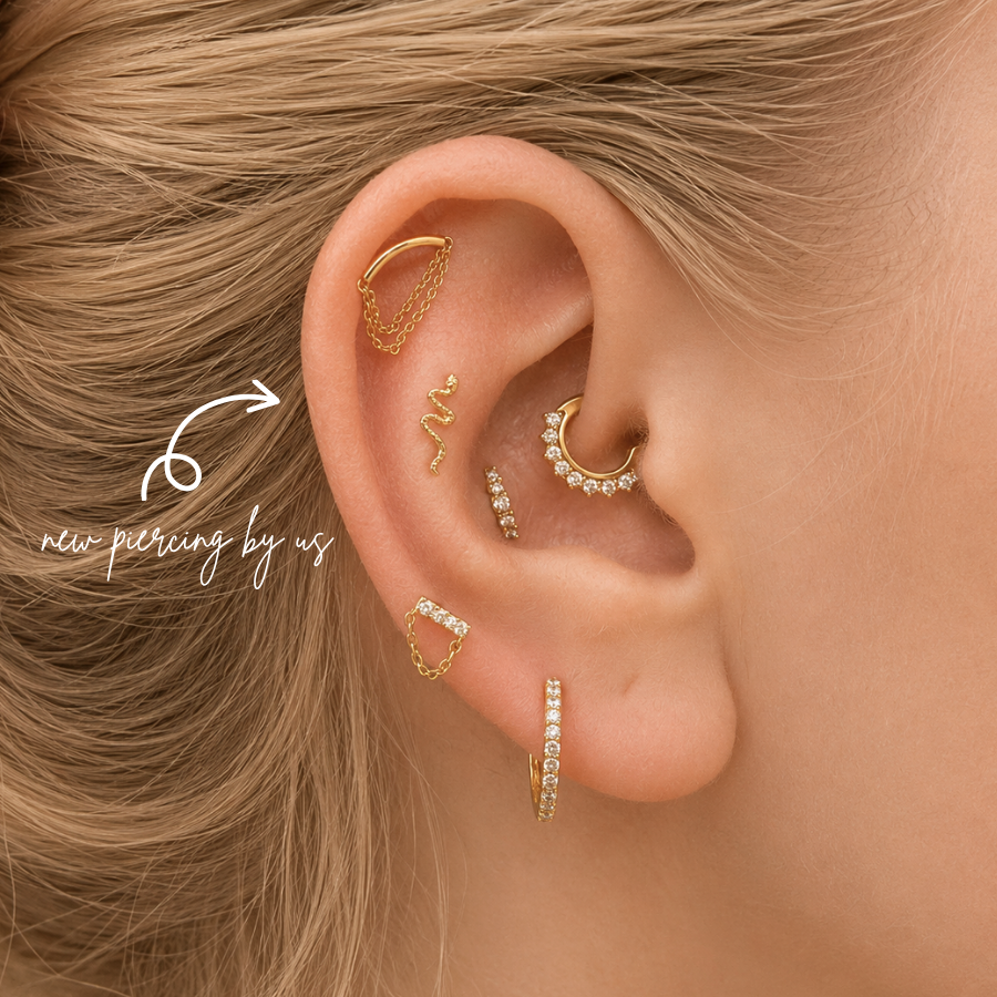 DOVIANA NYC curated ear piercing featuring a gold snake cartilage stud, crystal chain ear cuff, pavé conch hoop, and minimalist gold piercing jewelry for everyday ear stacks in New York.