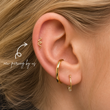 DOVIANA NYC curated ear piercing featuring a gold snake cartilage stud, gold conch hoop, crystal lobe hoop, and minimalist piercing jewelry for everyday ear stacks in New York.