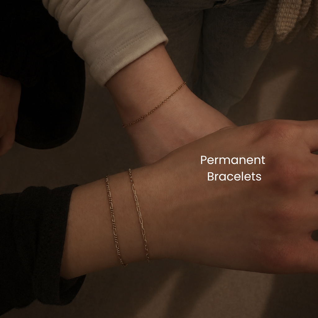 Stacked 14K gold or gold-filled permanent bracelets on wrist at DOVIANA NYC featuring delicate layered chains for everyday luxury styling