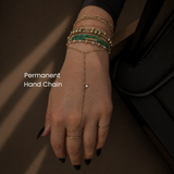 DOVIANA permanent bracelets in NYC featuring layered solid gold chains, beaded bracelets, and a delicate hand chain on wrist