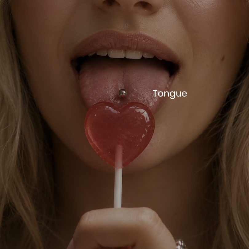 Close-up of tongue piercing with titanium barbell jewelry and heart-shaped lollipop styled in an edgy minimalist body piercing aesthetic at DOVIANA NYC.