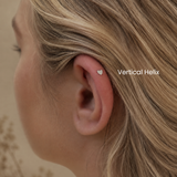 Close-up of vertical helix piercing with heart-shaped flat back earring styled in a minimalist curated ear aesthetic at DOVIANA NYC.