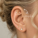 DOVIANA NYC curated ear piercing featuring hidden helix chain dangle earrings, gold CZ bezel studs, and minimalist fine piercing jewelry for everyday ear stacks in New York.