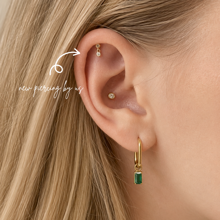 DOVIANA NYC curated ear piercing featuring a hidden helix dangle flat back earring, gold bezel conch stud, and emerald charm hoop for minimalist fine piercing jewelry in New York.