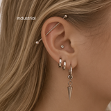 DOVIANA NYC industrial piercing service featuring a silver barbell across the upper ear with curated silver ear jewelry for professional ear piercings in New York.