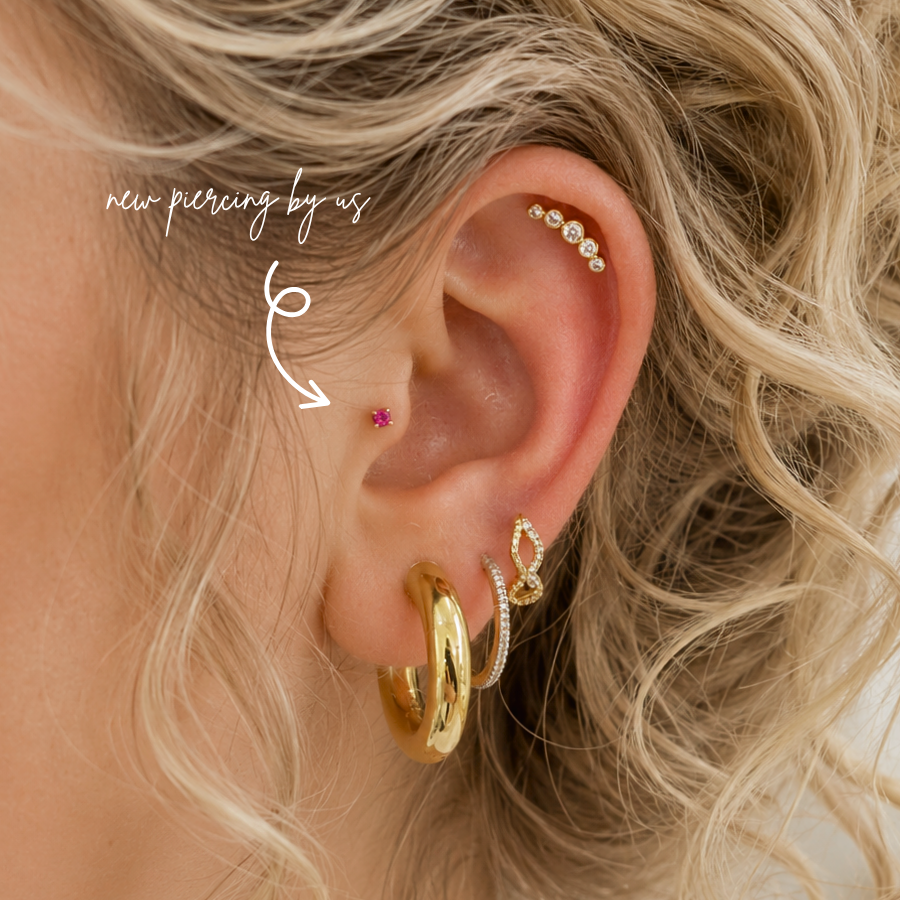 Fresh tragus piercing by DOVIANA NYC in Manhattan, New York, featuring a pink gemstone stud, professional cartilage piercing services, and personalized ear styling.